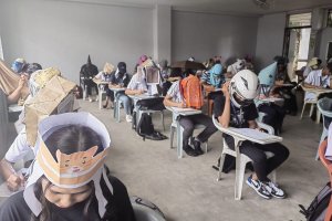 Снимки на филиписнки студенти с  шапки против преписване на главите по време на
