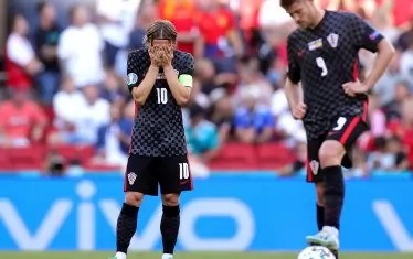 Капитанът на хърватите Лука Модрич (вляво) се държи за главата, докато Андрей Крамарич се готви да поднови играта след поредния гол на Испания.