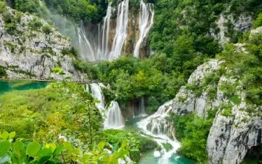 Сред зеленината на националния парк Плитвишки езера се спускат множество водни каскади.